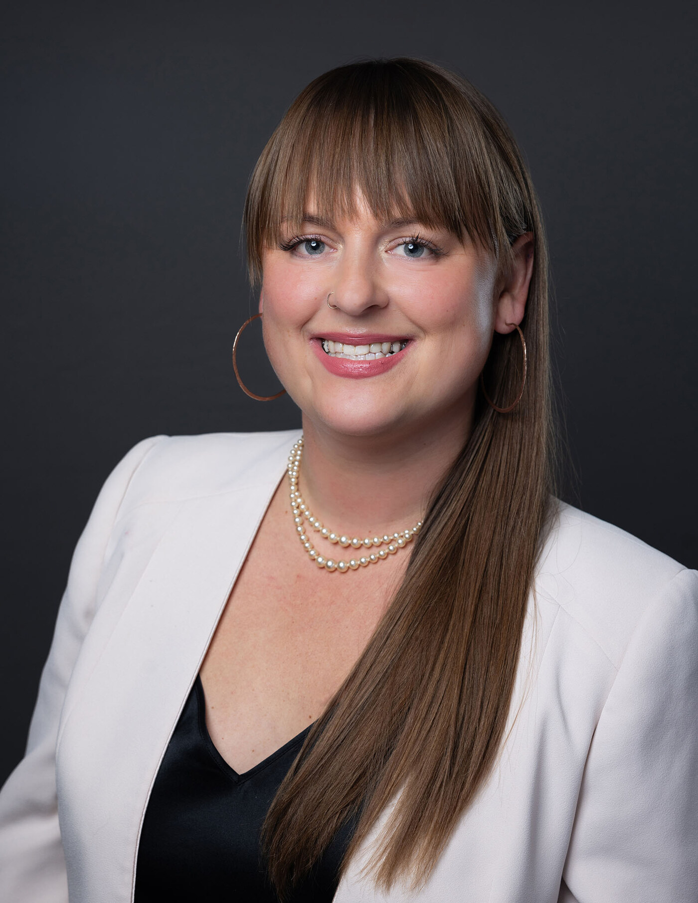 Official Province of British Columbia ministerial portrait of Brittny Anderson: a studio headshot against a dark grey background.