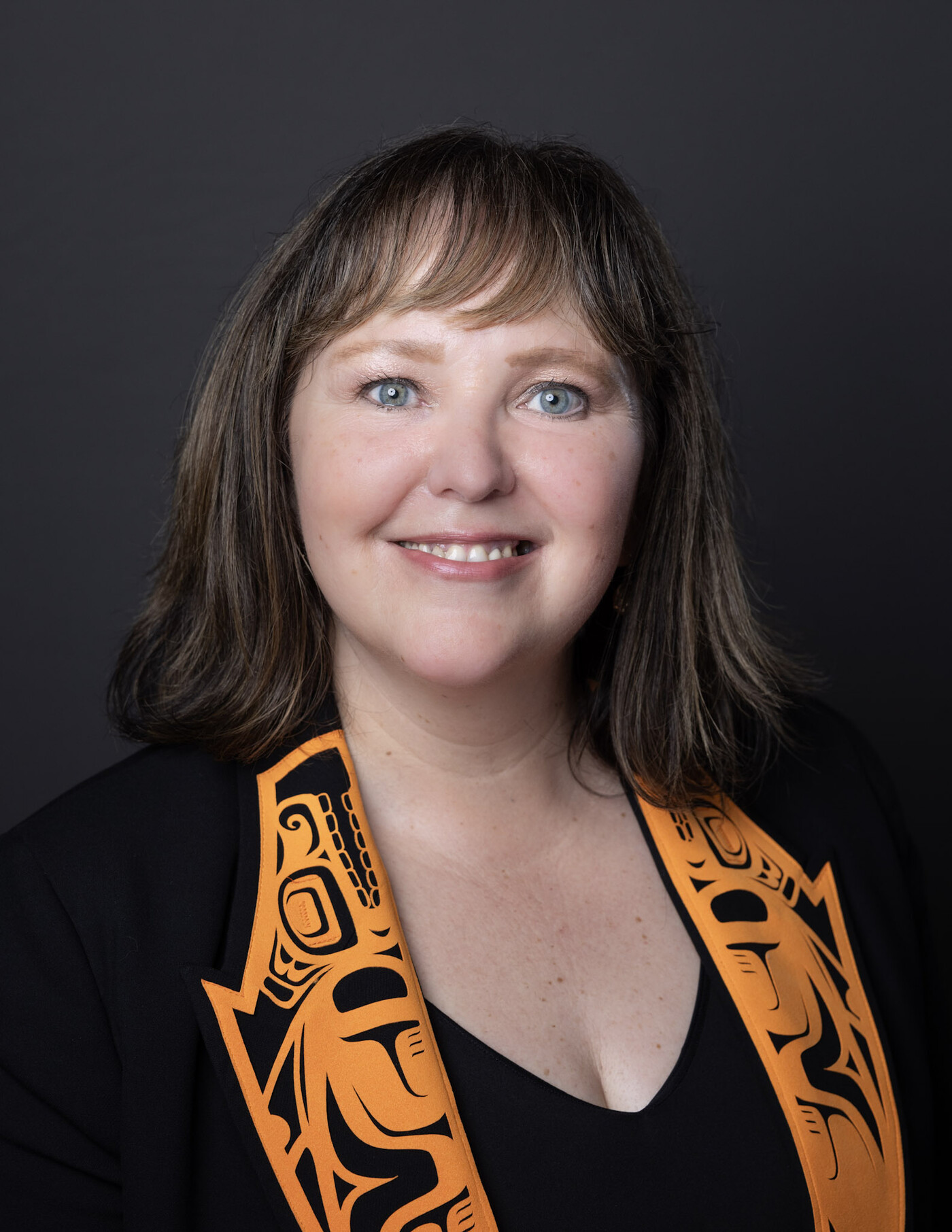 Official Province of British Columbia ministerial portrait of Tamara Davidson, Minister of Environment and Parks: a studio headshot against a dark grey background.