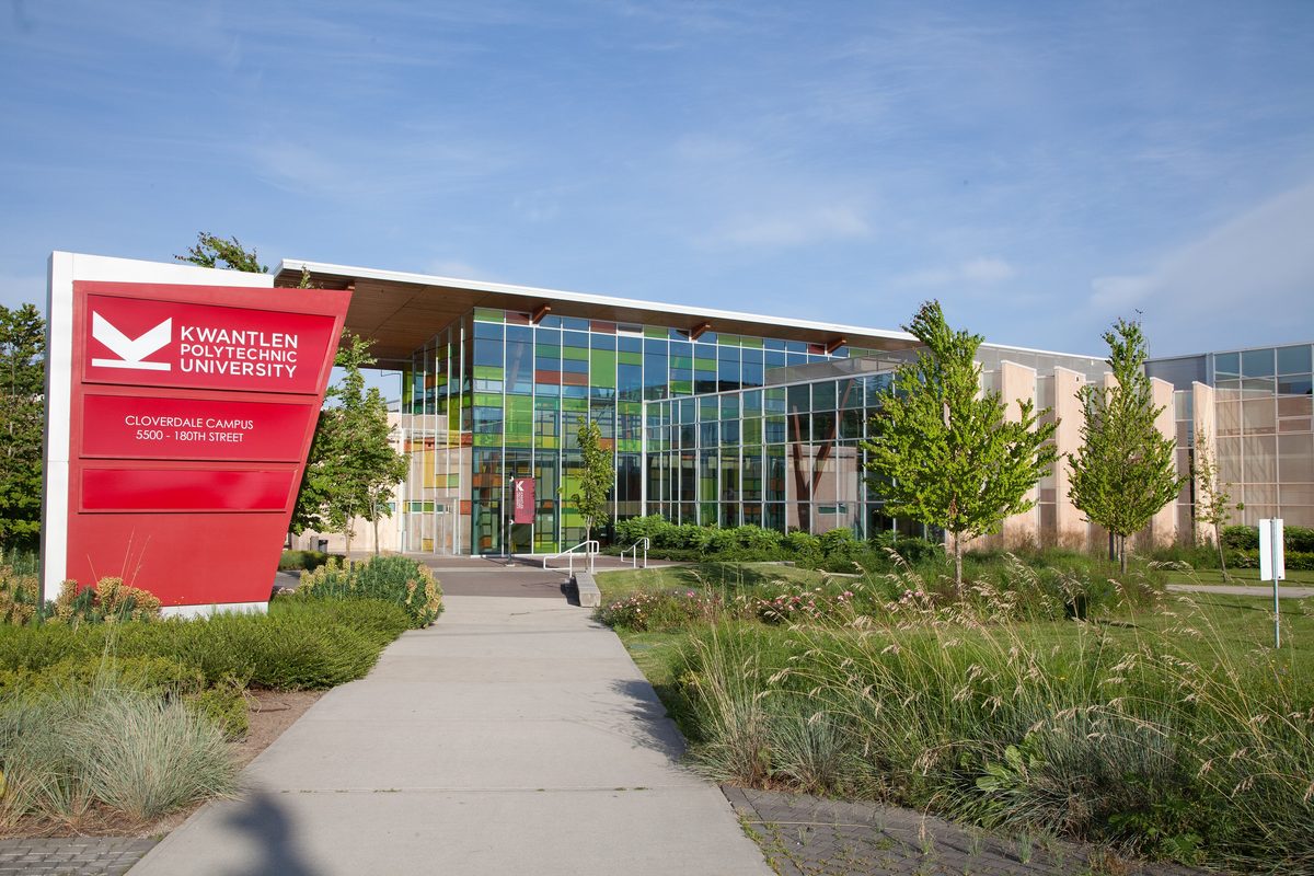 Kwantlen Polytechnic University&rsquo;s Cloverdale campus sign, reading 5500 180th Street, in front of a glass building on a summer day.