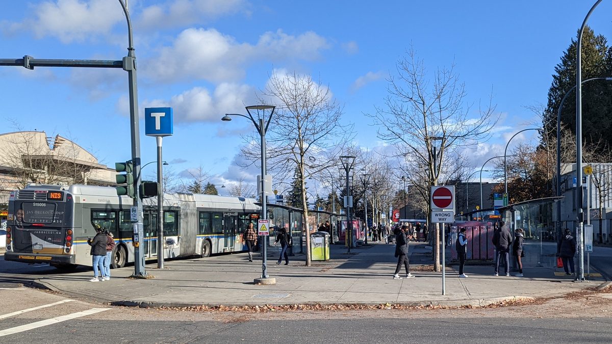 The Newton Exchange on King George Boulevard: a bus at the curb, shelters, and people waiting on the sidewalk.