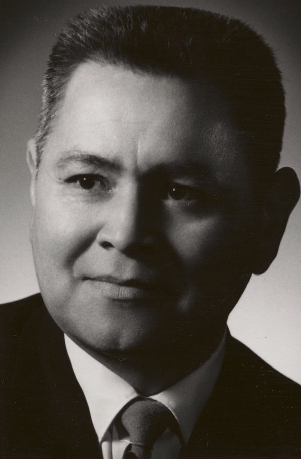 A black-and-white studio portrait of Frank Calder in a suit and tie.